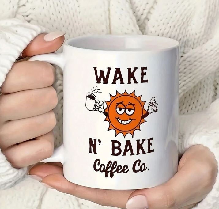 Wake N Bake Coffee Co Mug with cartoon sun design and ergonomic handle.