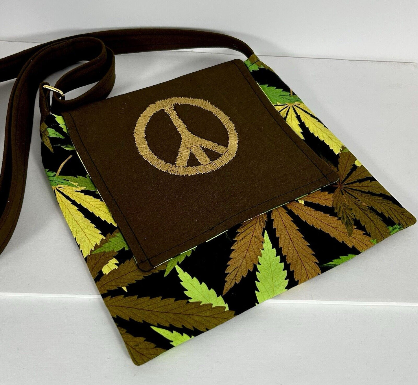 Handmade cannabis crossbody purse with embroidered peace sign.