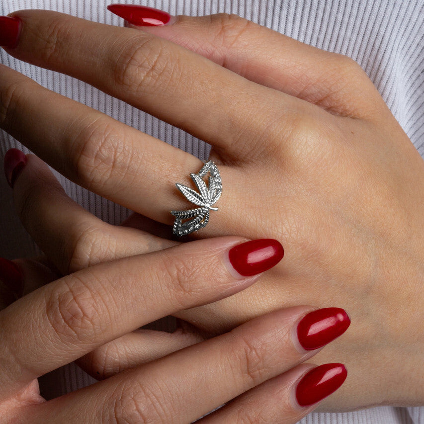 925 sterling silver marijuana leaf ring with cubic zirconia accents worn on hand.