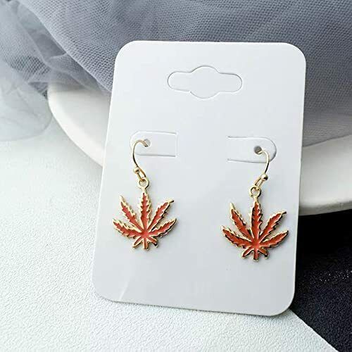 Red marijuana pot leaf earrings on display card.