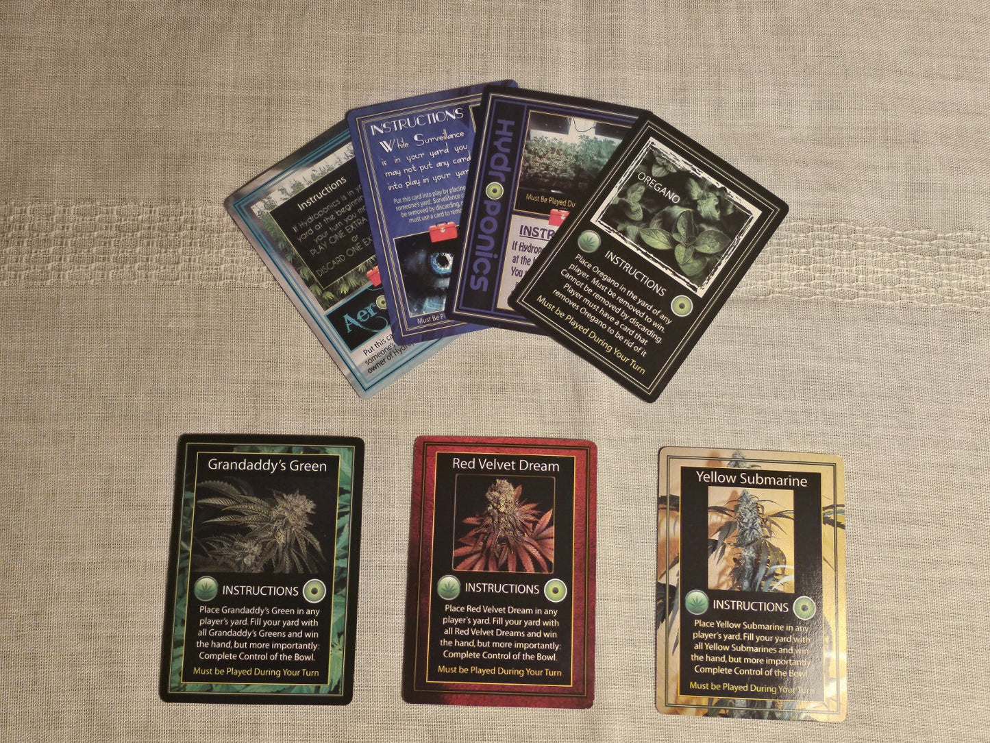Adult Cannabis Card Game cards displayed on a table, featuring various game instructions and designs.