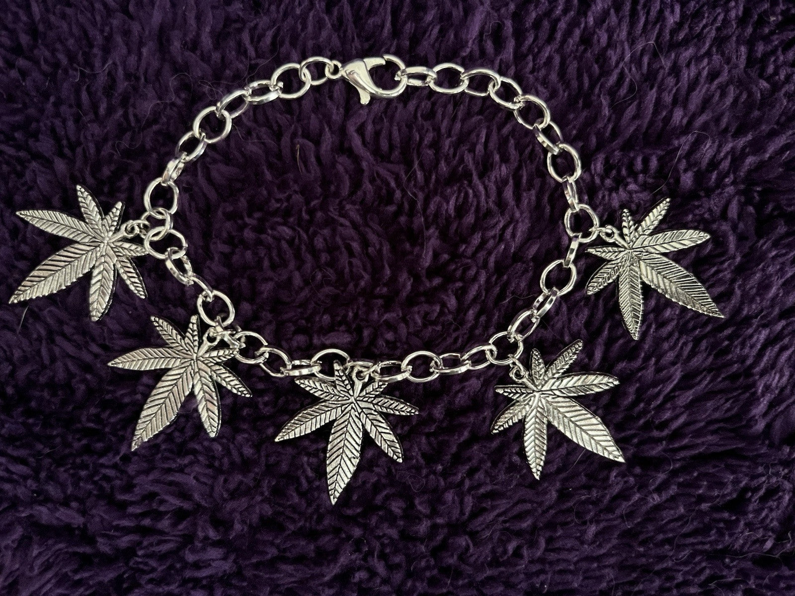 Pot leaf charm bracelet with five leaf charms on an adjustable chain.