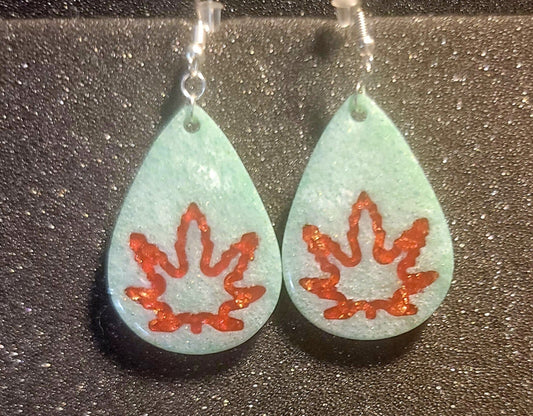 Green dangle earrings with pot leaf design, handcrafted from high-quality materials.