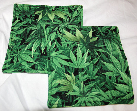 Marijuana pot leaf print cotton pot holders set on black background, 7" square.