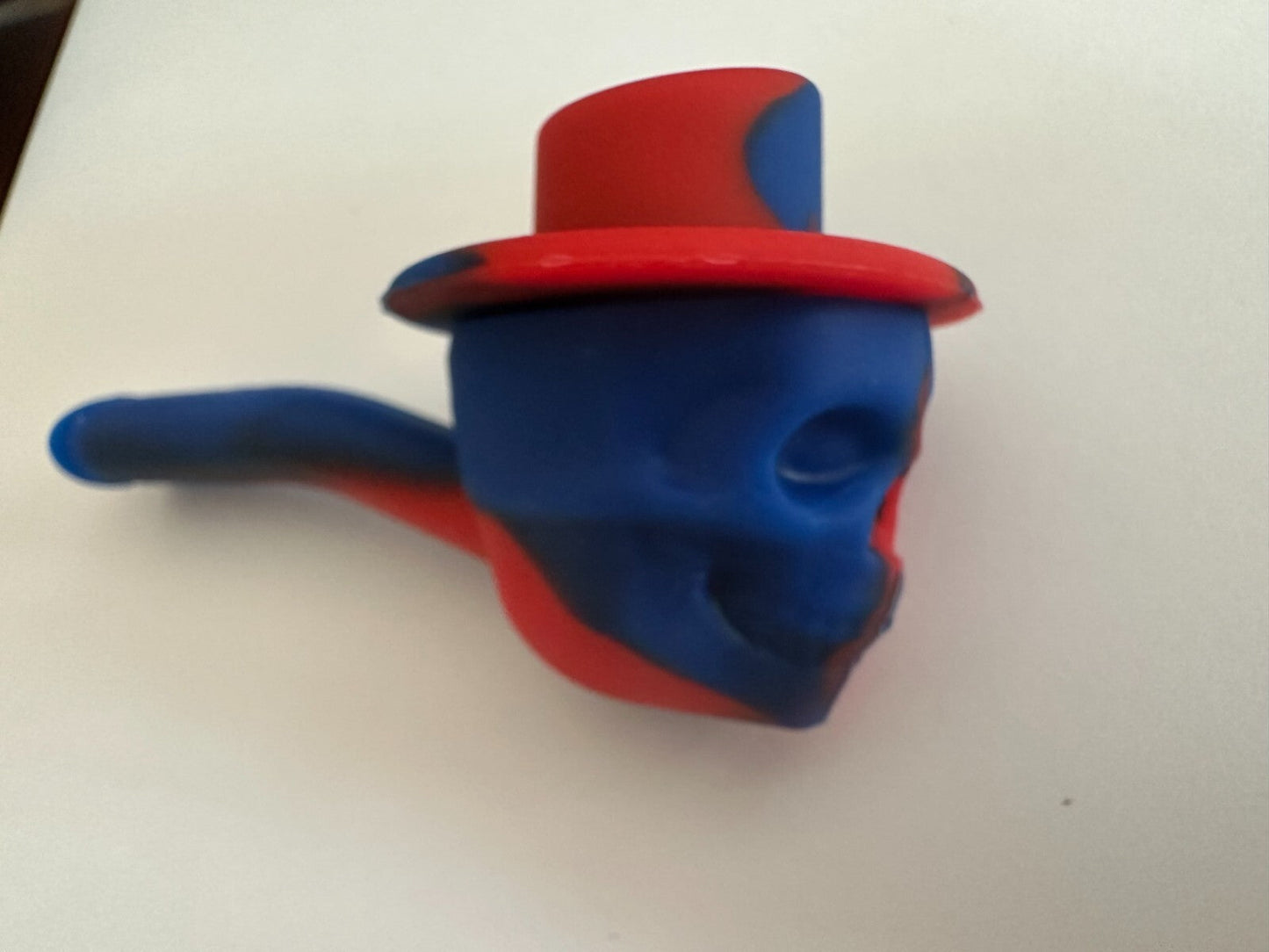 4.5″ silicone hand pipe with red and blue skull design, travel size.