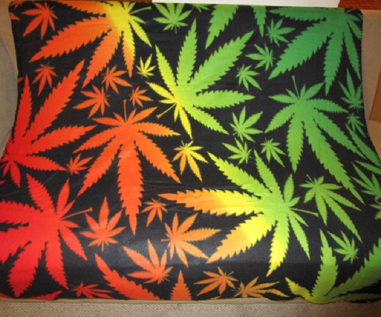 Colorful marijuana pot leaves fleece throw blanket with stitched edging.