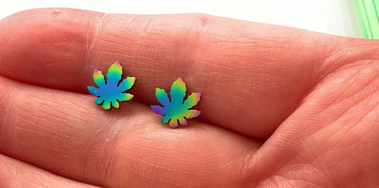 Mini stainless steel Marijuana Leaf stud earrings in hand.