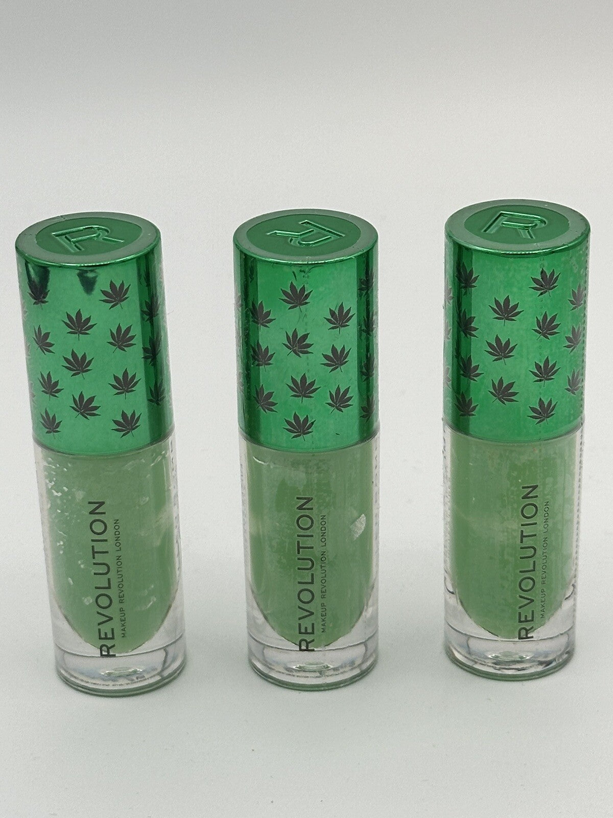 Revolution Good Vibes Chilled Bomb Lip Oil set of 3 vials with green caps and leaf design.