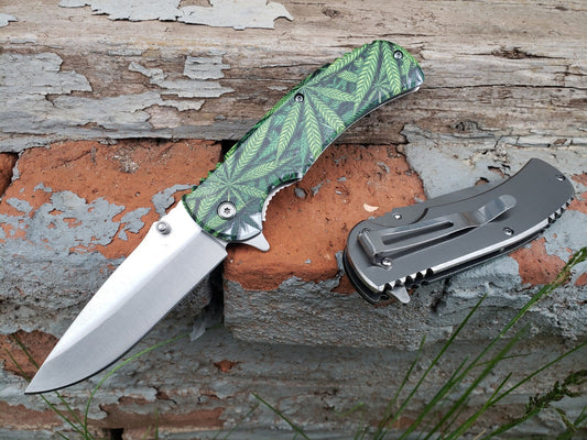 Silver green marijuana leaf print spring assisted pocket knife with stainless steel blade.